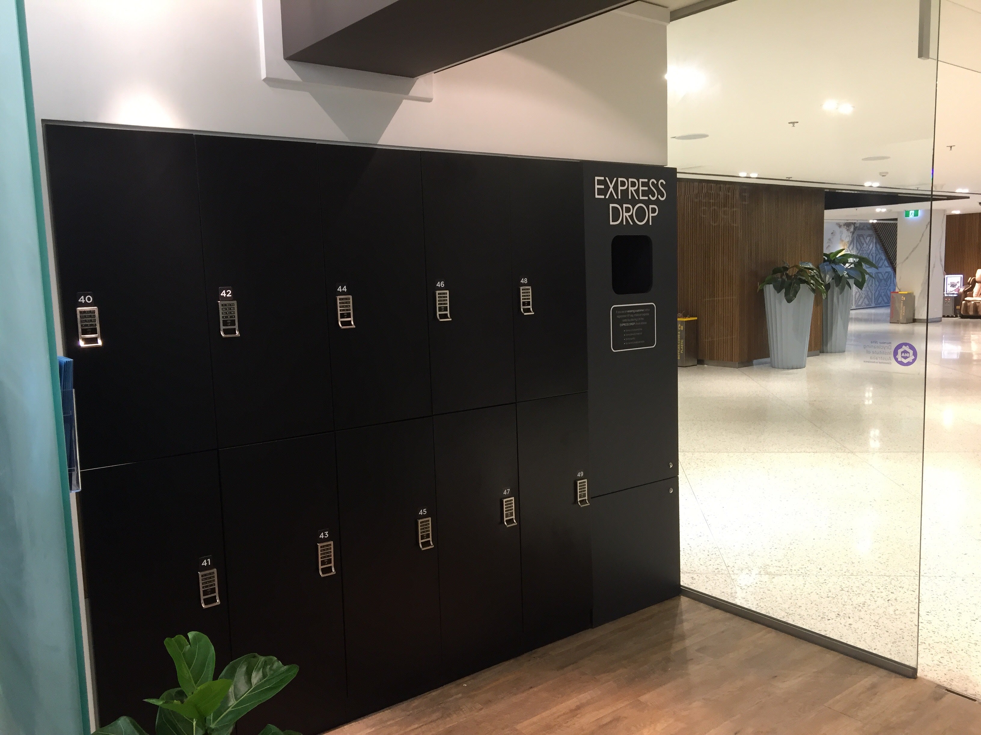 Laundry Warehouse 24/7 retail storefront with bank of black smart laundry lockers operating as a fully unattended pickup and drop-off point
