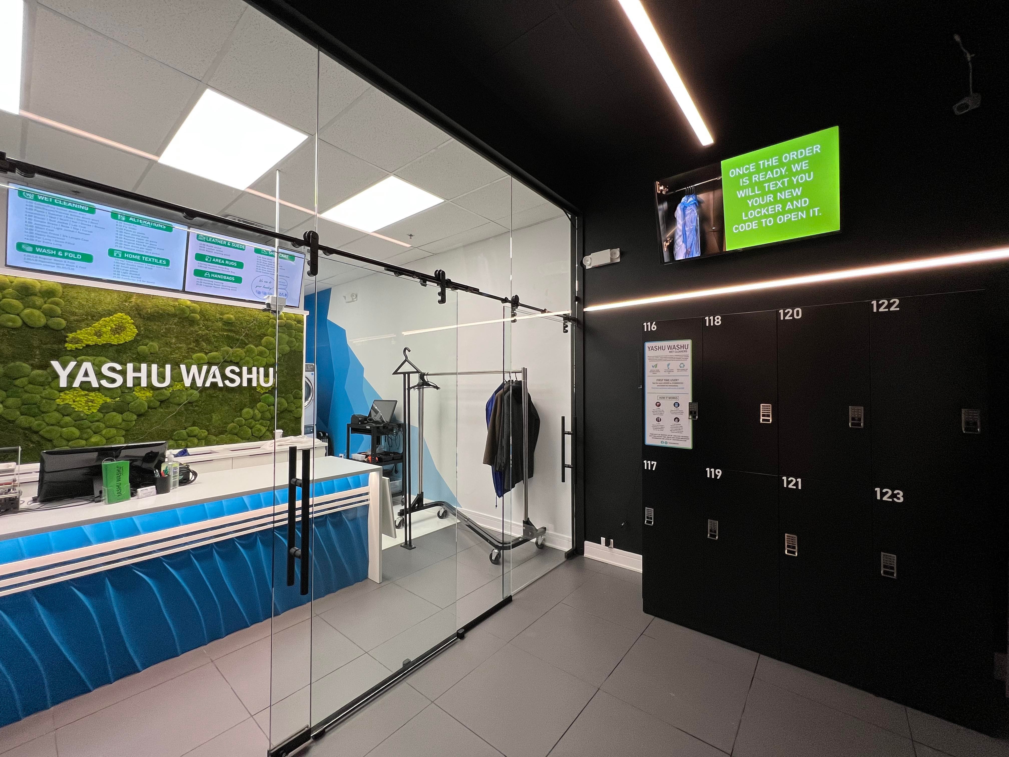 Yashu Washu retail store interior with bank of black numbered laundry lockers and digital instruction display